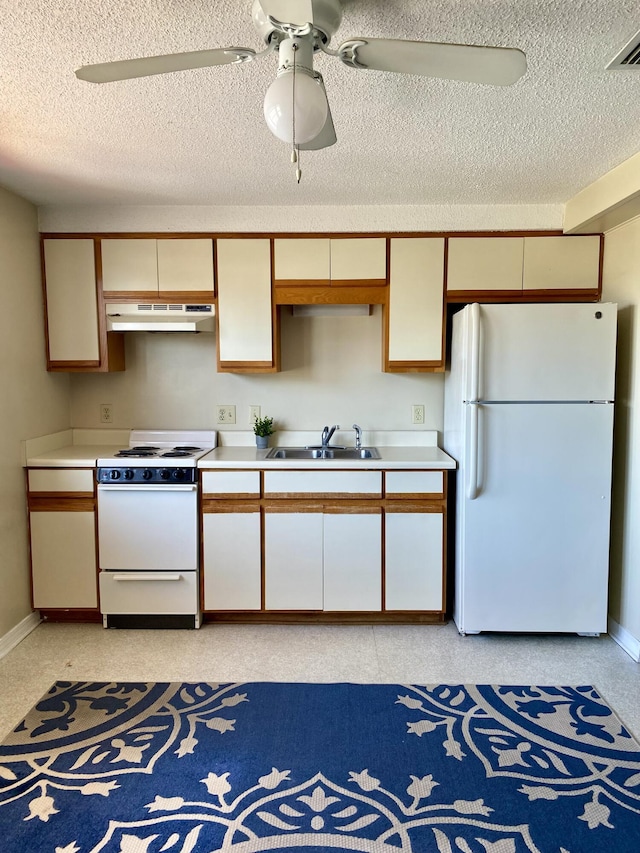 kitchen featuring white appliances, visible vents, light countertops, under cabinet range hood, and a sink