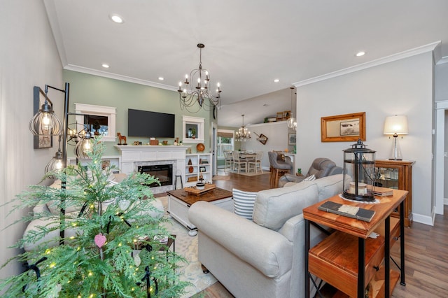 living room with hardwood / wood-style flooring, ornamental molding, a premium fireplace, and a chandelier