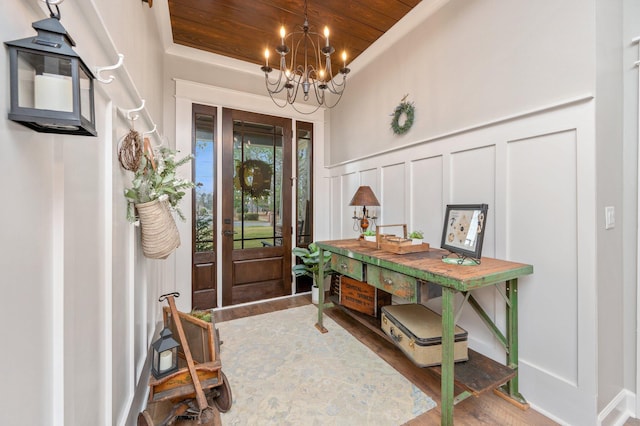 entrance foyer with an inviting chandelier, hardwood / wood-style flooring, and wooden ceiling