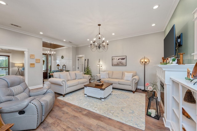 living room with ornamental molding, light hardwood / wood-style floors, and a notable chandelier