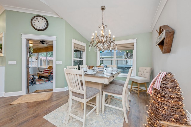 dining room with hardwood / wood-style flooring, vaulted ceiling, and ornamental molding