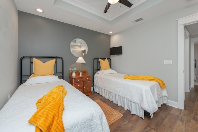 bedroom featuring a raised ceiling, ceiling fan, and dark hardwood / wood-style flooring