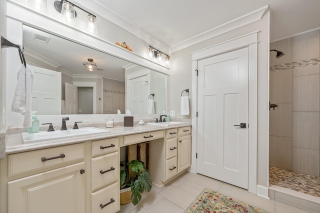 bathroom featuring crown molding, vanity, and a tile shower