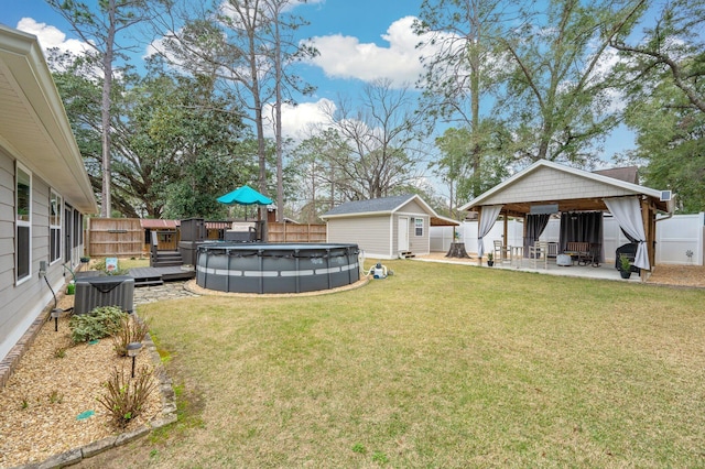 view of yard with central air condition unit, a gazebo, a covered pool, a shed, and a patio area