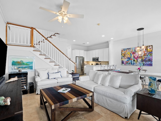 living area featuring ceiling fan with notable chandelier, stairway, recessed lighting, and crown molding