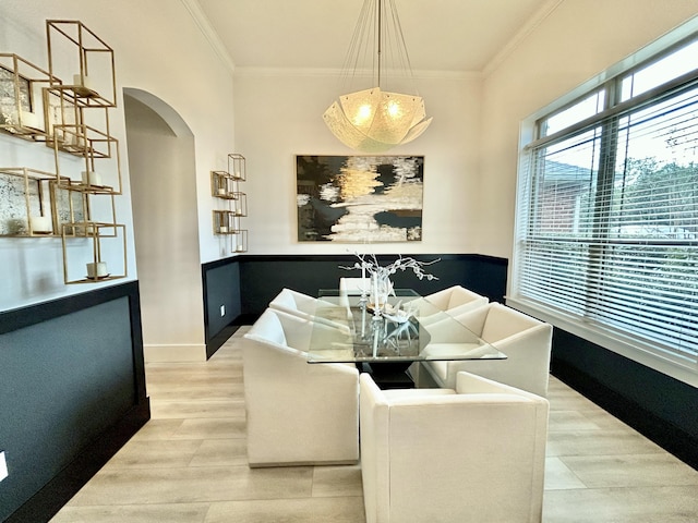 dining space with crown molding and light hardwood / wood-style floors