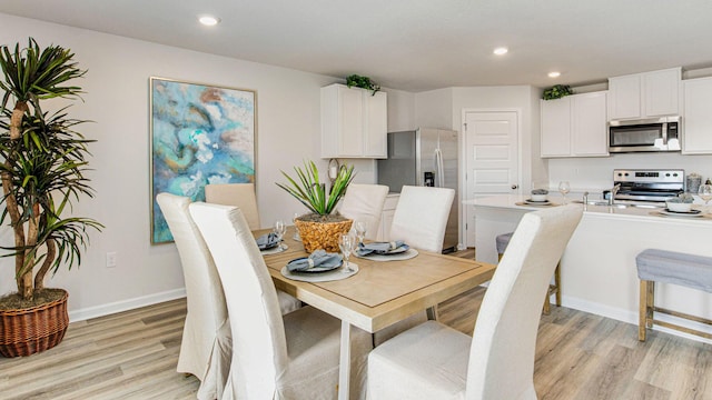 dining area with recessed lighting, baseboards, and light wood finished floors