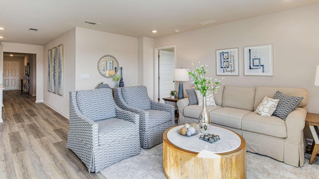 living area with baseboards, wood finished floors, visible vents, and recessed lighting