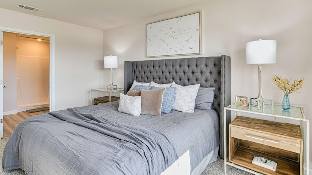 bedroom featuring wood finished floors and visible vents