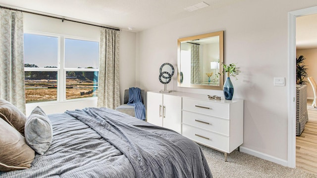 bedroom featuring light colored carpet, visible vents, and baseboards