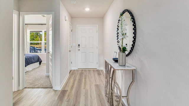 foyer with light wood-style floors and baseboards