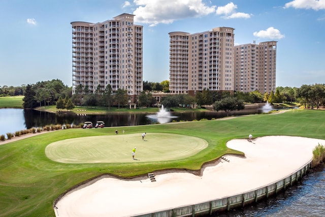 surrounding community with a water view and a lawn