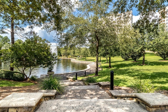 view of community with a water view and a lawn