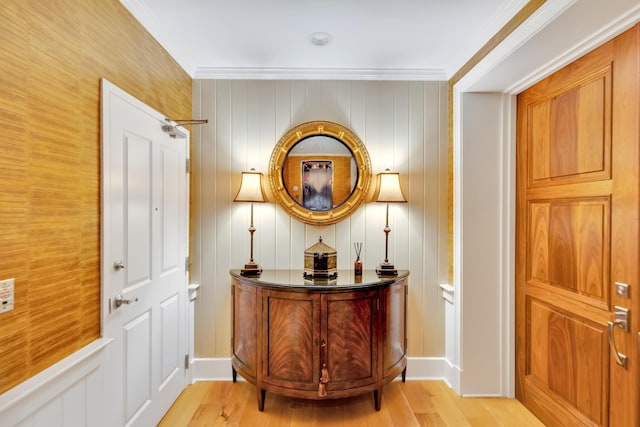 hall with light hardwood / wood-style floors and crown molding