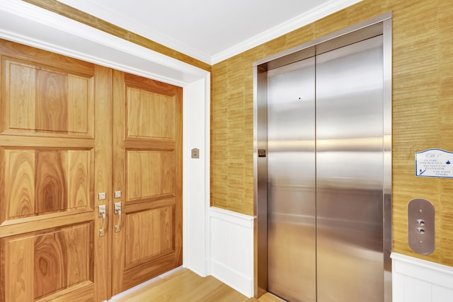 interior space featuring light wood-type flooring, elevator, and ornamental molding