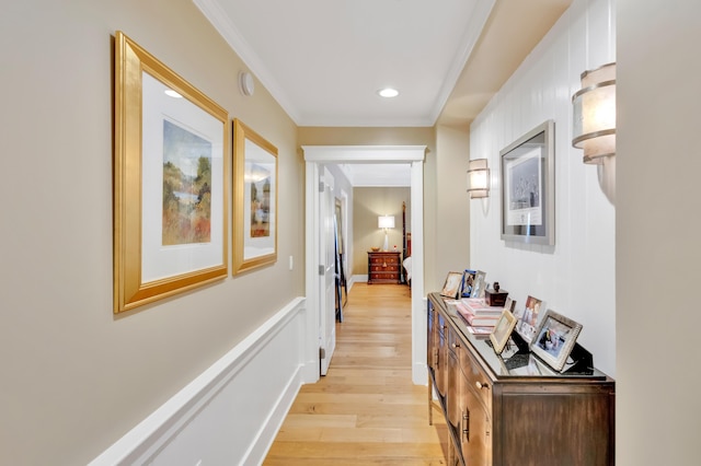 corridor featuring light wood-type flooring and ornamental molding