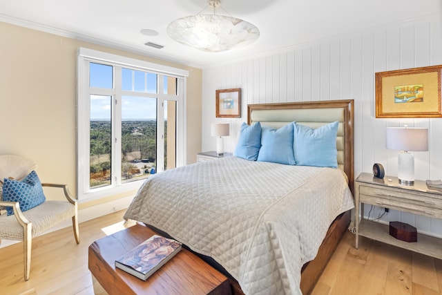 bedroom with light hardwood / wood-style floors and crown molding