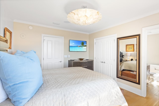 bedroom with a closet, hardwood / wood-style flooring, and crown molding