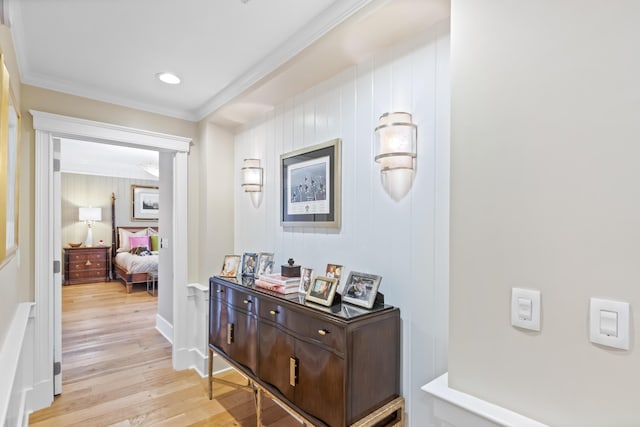 hallway featuring light wood-type flooring and ornamental molding