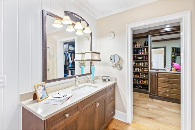 bathroom with hardwood / wood-style flooring, crown molding, and vanity