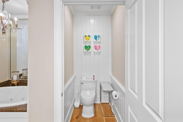 bathroom with ornamental molding, toilet, hardwood / wood-style flooring, and a chandelier