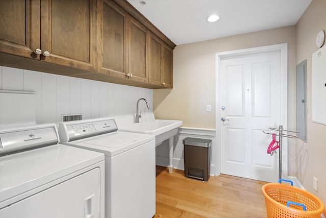 laundry room with cabinets, sink, light wood-type flooring, and independent washer and dryer