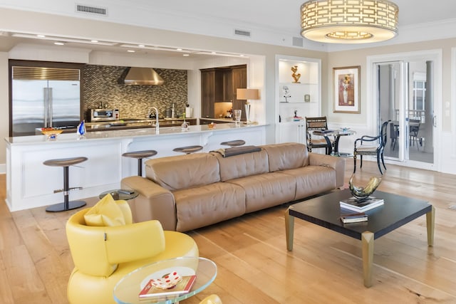 living room featuring light hardwood / wood-style floors and ornamental molding