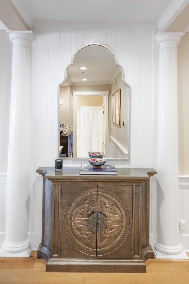 bar with crown molding, ornate columns, and wood-type flooring