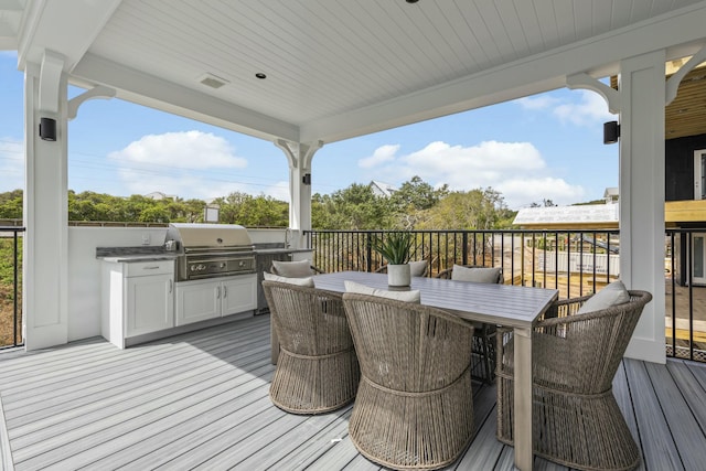 wooden terrace with an outdoor kitchen and grilling area