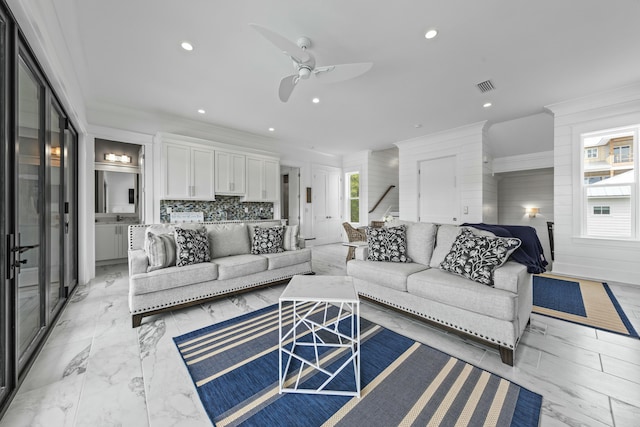 living room with crown molding and ceiling fan