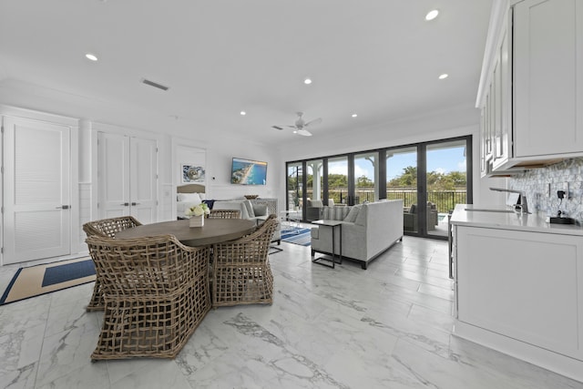 dining area with ceiling fan and ornamental molding