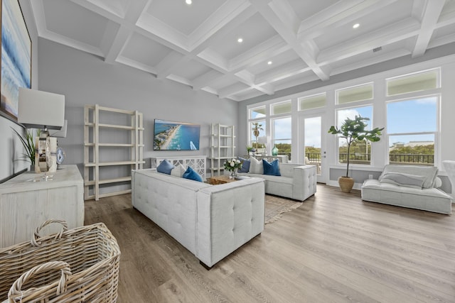 living room with beamed ceiling, a high ceiling, coffered ceiling, and hardwood / wood-style floors