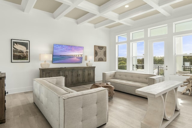 living room with coffered ceiling, beam ceiling, light hardwood / wood-style floors, and a high ceiling