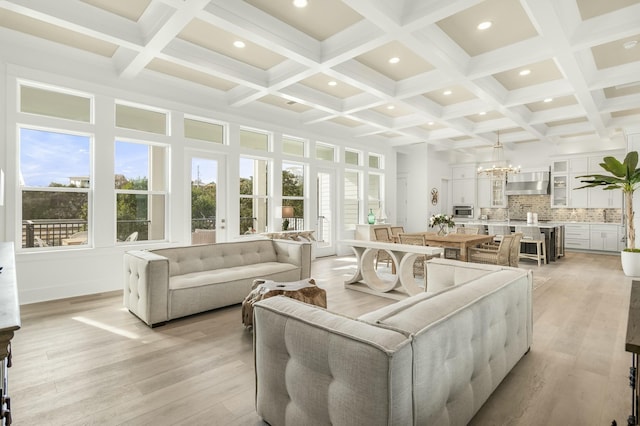 interior space featuring coffered ceiling, a chandelier, and beamed ceiling