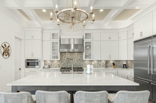 kitchen featuring light stone counters, appliances with stainless steel finishes, a large island, and a kitchen breakfast bar