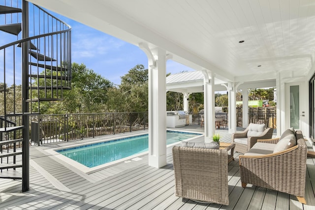 view of pool with a grill, an outdoor hangout area, and an outdoor kitchen