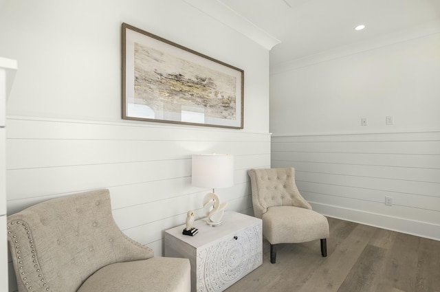 living area with ornamental molding and hardwood / wood-style floors