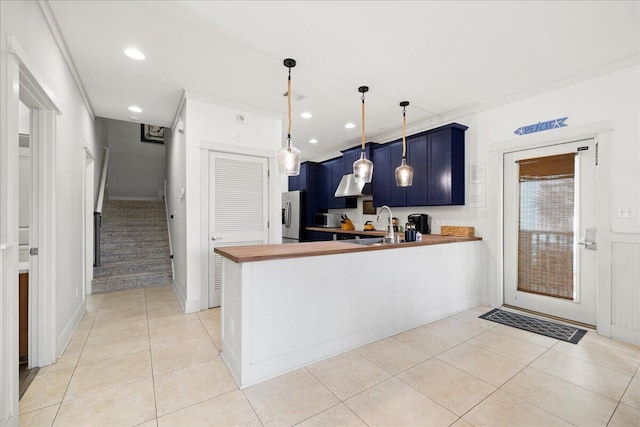 54 Rue Du Soleil, Santa Rosa Beach, FL 32459 - kitchen with blue cabinetry, stainless steel fridge, a peninsula, light tile patterned floors, and recessed lighting