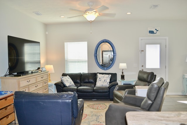 living room with ceiling fan and light hardwood / wood-style flooring