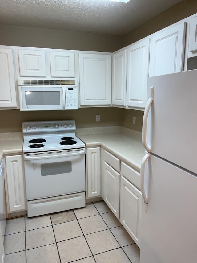 kitchen featuring light tile patterned floors, white cabinets, white appliances, and light countertops