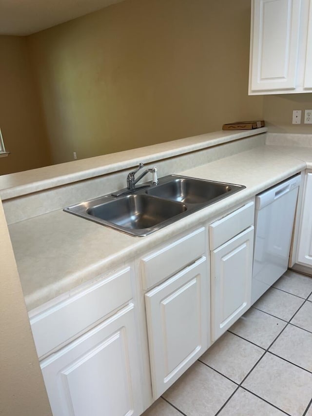 kitchen featuring white cabinetry, light tile patterned floors, white dishwasher, and a sink