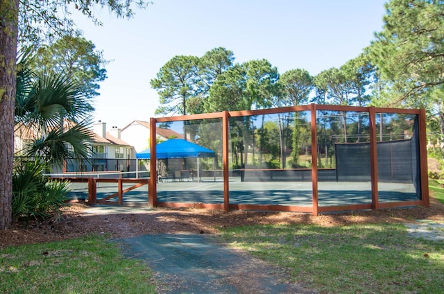 view of jungle gym with a tennis court and fence