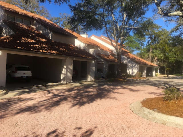 view of front of house featuring a garage, stucco siding, and a tiled roof