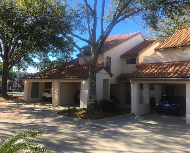 view of front of house with a garage, concrete driveway, stucco siding, and a tile roof