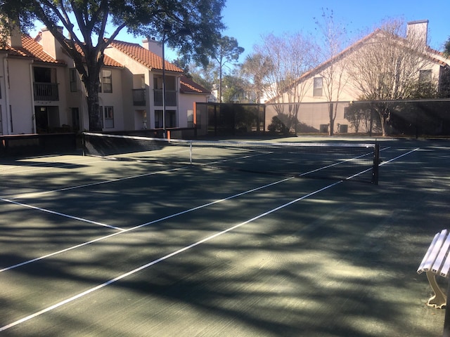 view of tennis court featuring fence