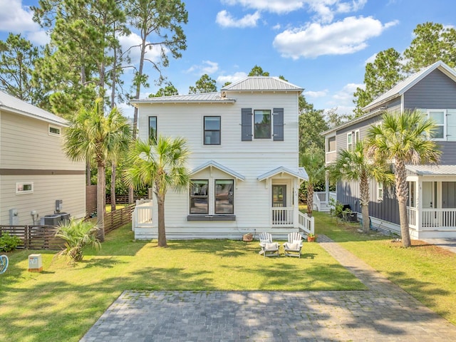 view of front of home featuring central AC unit, metal roof, fence, and a front lawn