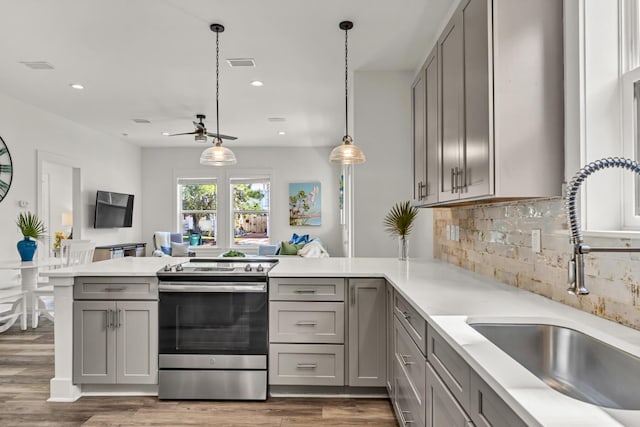 kitchen with visible vents, a peninsula, stainless steel electric range, gray cabinets, and a sink