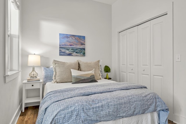 bedroom with a closet, baseboards, and wood finished floors