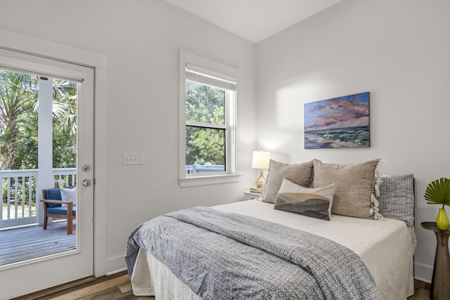 bedroom featuring multiple windows, wood finished floors, and baseboards