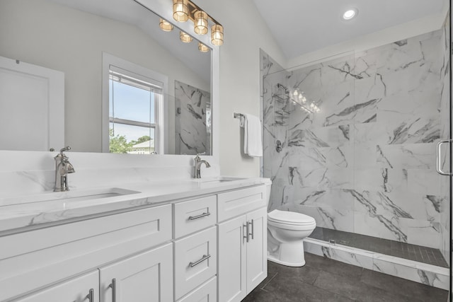 bathroom featuring toilet, double vanity, a marble finish shower, and a sink